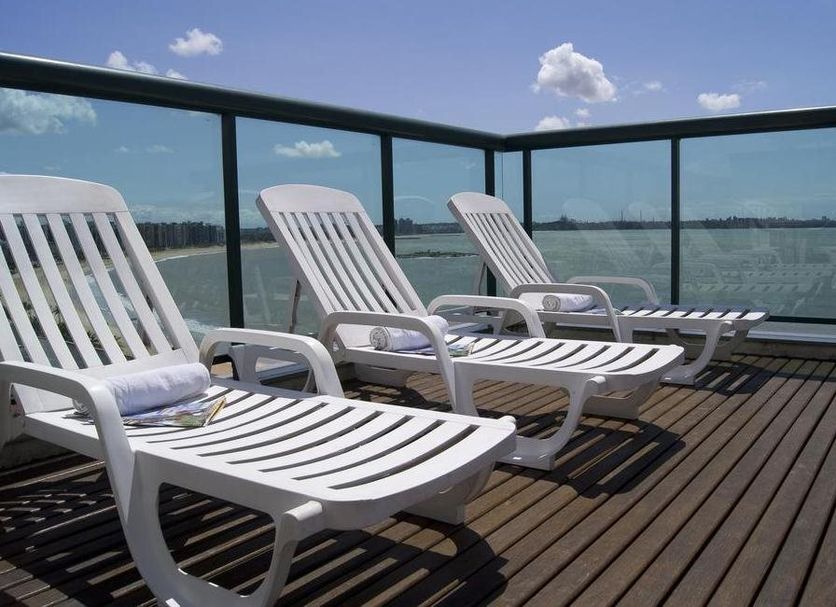 Bourbon Vitoria Residence Hotel in Vitória with lounge chairs on a deck overlooking the water
