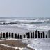 Beachfront view at Hotel Le Canada in Hermanville-sur-Mer with waves and wooden groynes
