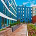 Aloft Seattle Redmond in Redmond, exterior courtyard with wooden walkway, landscaping and modern buildings