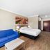 Days Inn by Wyndham Rockdale Texas room with blue sofa, bed, lamp, coffee table and wood-look floor