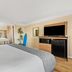 Travelodge by Wyndham San Clemente Beach guest room with king bed, TV, mini fridge and sink
