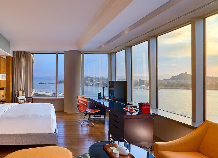 Hotel Indigo Xiamen Harbour guest room with harbor and city views through floor-to-ceiling windows