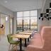 Hampton Inn Crossville meeting room with tables, green chairs, pink sofa and large window view
