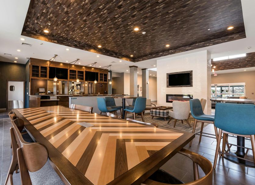 Four Points by Sheraton Elkhart lobby lounge with communal table, bar seating and mounted TV