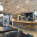 Dorma Juan De Austria in Valladolid features a modern bar with curved counter, stools, and circular ceiling lights.