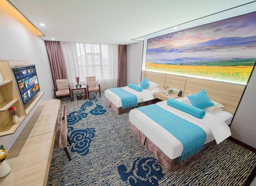 Marriott Hotel Yunfu guest room with two twin beds, seating area, and large landscape wall mural