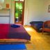 Sans Souci Inn, Pohara: simple guest room with two beds, wicker chair, and garden-view door