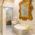 Casa Nostra Boutique Hotel in Paraty bathroom with glass shower, ornate gold mirror and marble sink