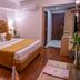 Sun Park Resort, Chandigarh bedroom with king bed, wooden floor, bedside lamps and seating area