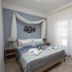 Panorama Junior Suites in Kavála: cozy bedroom with canopy bed, blue accents and sheer curtains