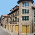 Hotel Villa de Cabrales in Las Arenas, stone hotel building on a quiet street with mountain backdrop