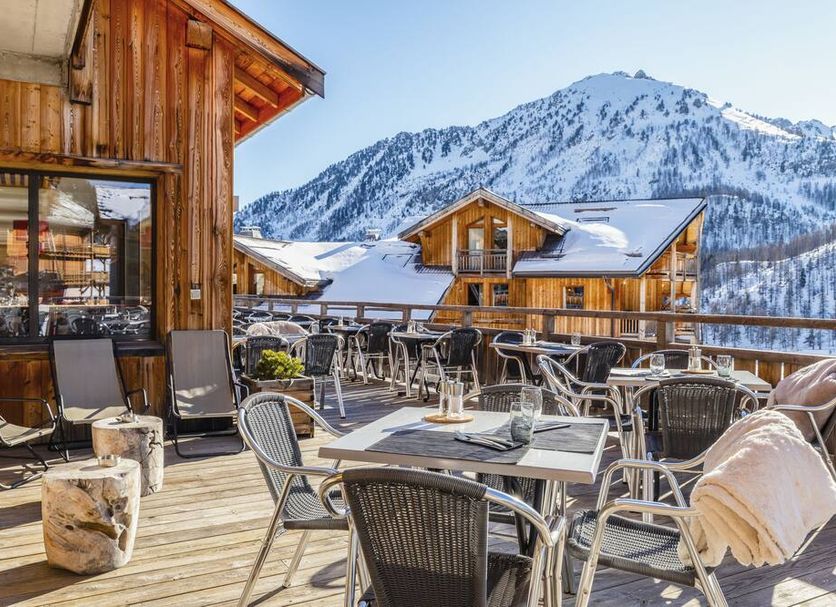Anova Hotel & Spa in Montgenèvre terrace with mountain views and outdoor seating in the snow