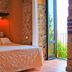 Marulivo Hotel, Pisciotta: double bed in an orange room with stone walls and open door to balcony