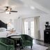 The Evers House Fredericksburg guest room with ornate bed, green chairs and French doors