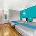 Motel 6 Raleigh North in Raleigh guest room with two beds and turquoise accent wall