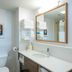 Hampton Inn and Suites Jamestown bathroom with vanity, large mirror, towels, and toilet