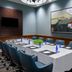The Westin Washington National Harbor meeting room with conference table, blue chairs, wall art and TV