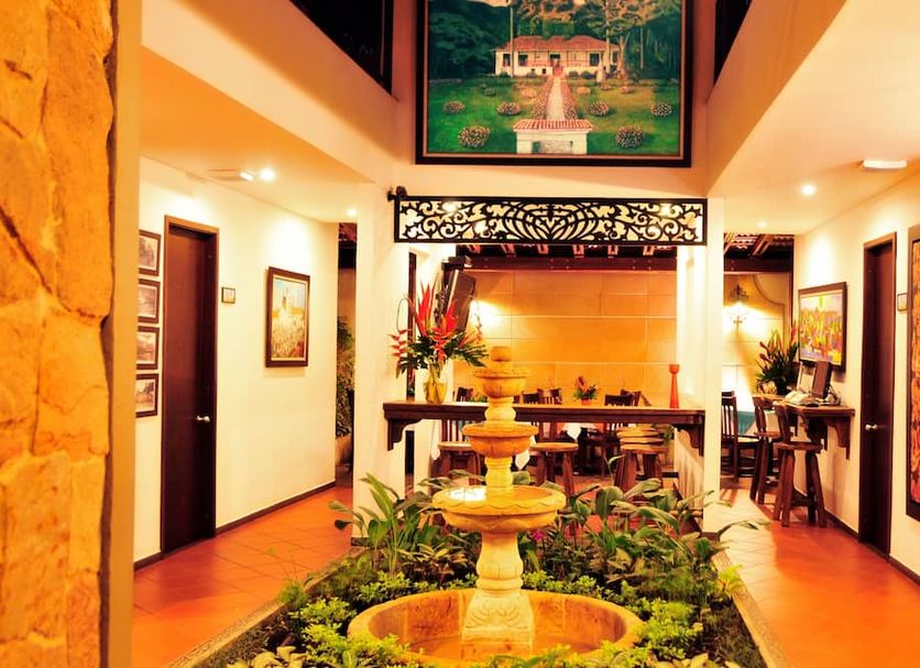Hotel Boutique San Antonio in Cali lobby with fountain, potted plants and warm lighting