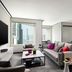 The Murray, Hong Kong lounge with city views, gray sofa, dining table and large windows