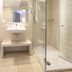 Hotel Marburger Hof bathroom in Marburg with glass shower, sink, mirror and bench