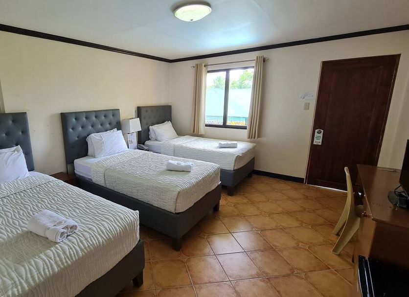 Marvin's Seaside Inn, Naval: guest room with three twin beds, window, desk and tiled floor