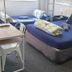 Backpackers Central Hamilton room with multiple single beds, desk, and window blinds in Hamilton