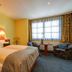 Hotel Elbinsel in Hamburg guest room with twin beds, window seating area and patterned chairs