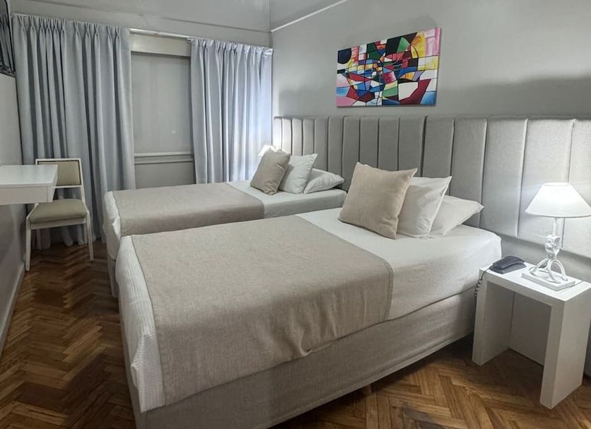 Facon Grande Buenos Aires guest room with two twin beds, desk, bedside lamp and colorful wall art