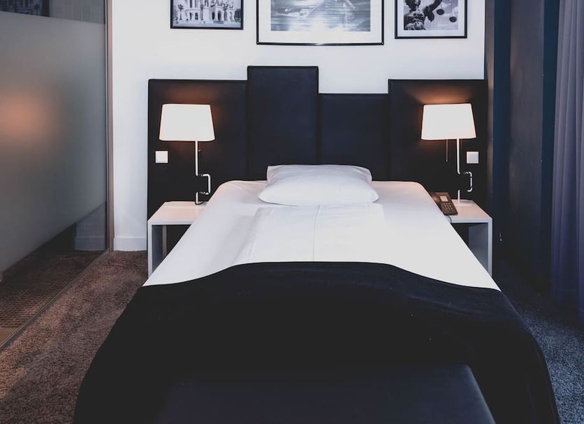 Hotel Bliss Frankfurt am Main guest room with twin lamps, neatly made bed, and framed wall art
