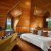Hotel Mountain Brook in Tannersville: wood-paneled guest room with fireplace, bed, and mountain-view window