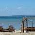 The Beach House in Mackinaw City with beach chairs facing a calm waterfront and distant shoreline