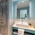 Hyatt Place London City East bathroom with glass shower, vanity sink and mirror in London