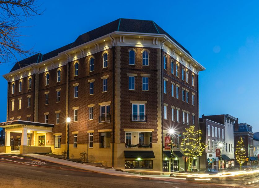 The Mount Vernon Grand Hotel in Mount Vernon, brick hotel exterior at dusk with lit windows and street view