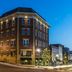 The Mount Vernon Grand Hotel in Mount Vernon, brick hotel exterior at dusk with lit windows and street view