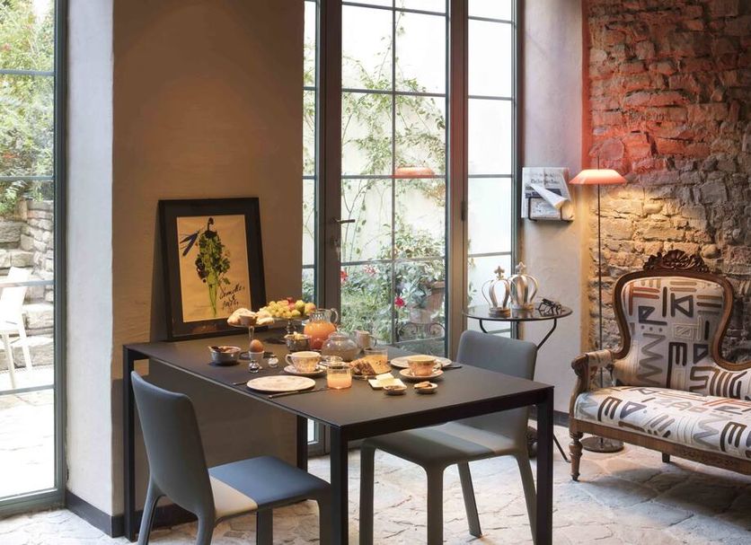 Ottantotto Firenze in Florence: stylish breakfast table beside large windows and a patterned lounge chair