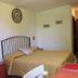 Flegrea House - Casa Rosa bedroom in Pozzuoli with double bed, wall clock, and desk