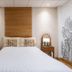 The Goose House Ubon room in Ubon Ratchathani with bed, sofa, and wood accent wall