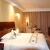 Guohao Hotel in Shijiazhuang guest room with king bed, desk, armchair, and floor-to-ceiling curtains