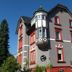 Hotel Markgräfler Hof in Badenweiler, gray hotel with red-trimmed windows and a turret balcony