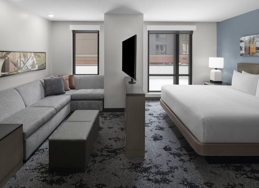 Hyatt House Raleigh Downtown/Seaboard Station room with sofa, bed, and city-view windows in Raleigh