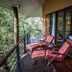 Rodavento Valle de Bravo balcony with striped lounge chairs overlooking lush forest