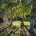 Shotover Lodge in Queenstown with landscaped garden, birch trees, and apartment balconies in sunlight