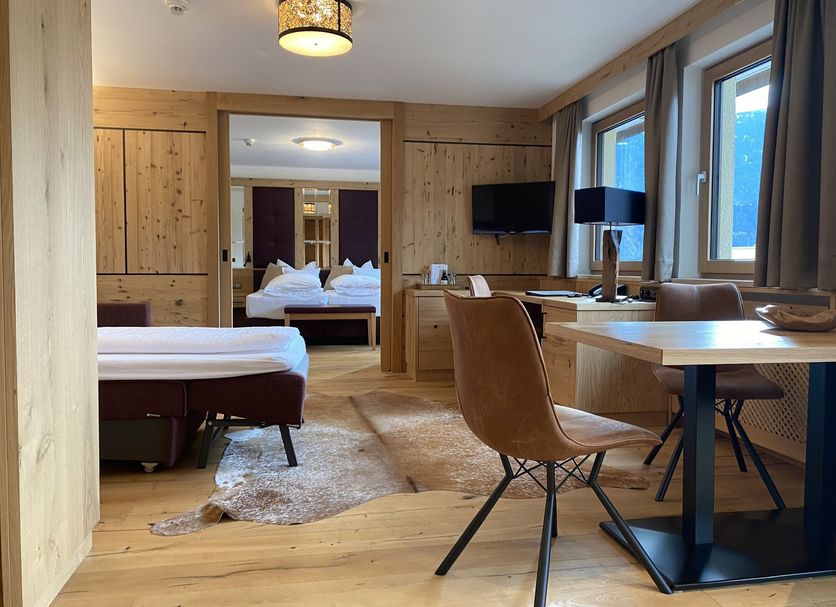 Tyrolis in Zirl: hotel room with desk, twin beds, wood-paneled walls and mountain-view windows