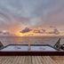 Fiesta Americana Cozumel seaside deck with twin loungers facing a colorful ocean sunset