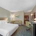 Best Western Wesley Chapel guest room with king bed, desk, chair and sitting area