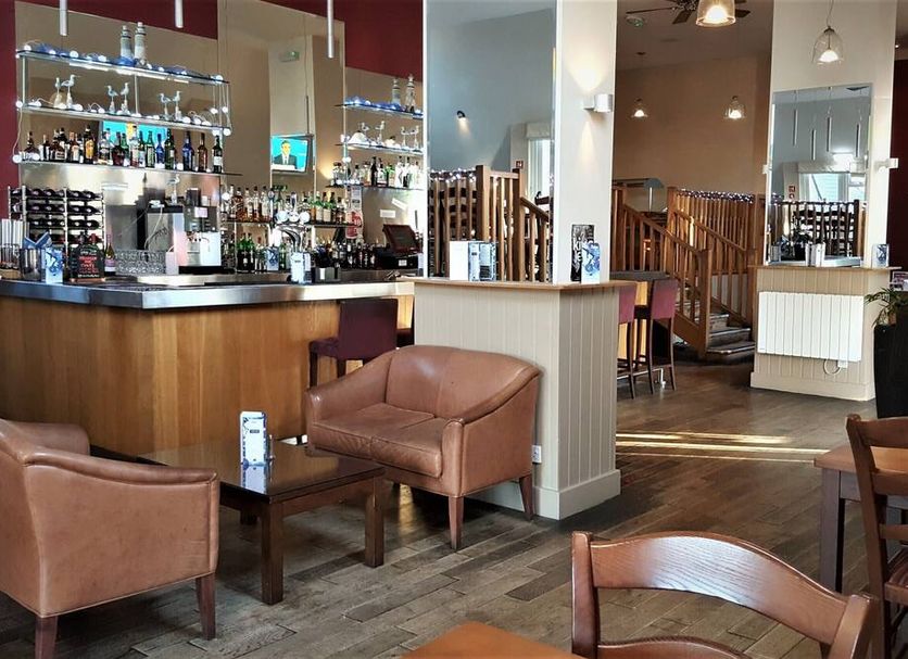 Winchelsea Lodge bar and lounge in Winchelsea with leather armchairs, wooden tables and staircase