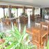 Nalla Eco Beach Resort, Pondicherry: bright restaurant dining room with wooden tables, chairs and potted plants