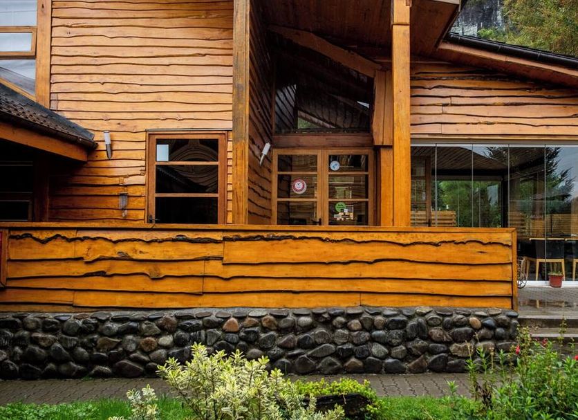 Hotel Alto Melimoyu in La Junta, wooden lodge exterior with stone base and large windows