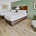 Best Western Plus Duncanville Dallas guest room with two beds, green armchair and ottoman in Duncanville