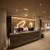 Reception desk at abba Sevilla in Seville with glowing wall sign and modern lobby seating